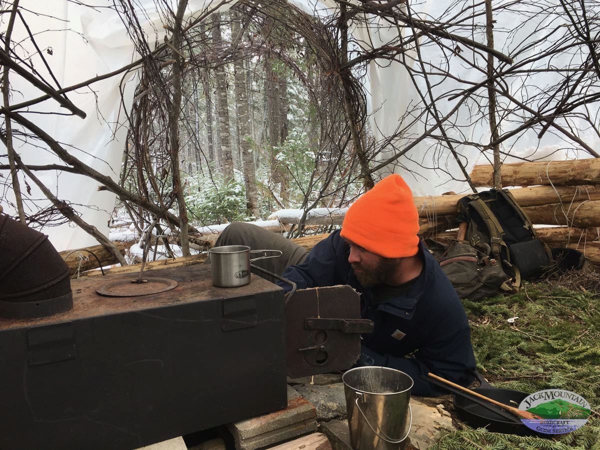Lighting a woodstove in a shelter on a snowy day