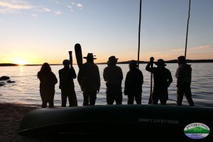 Canoe trippers on the beach watching the sunset