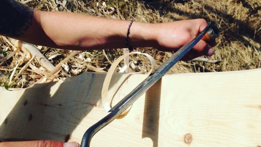 Using a draw knife to rough out a canoe paddle on a clear Tuesday morning