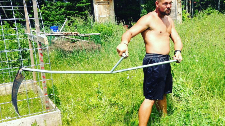 Using A Scythe To Cut The Grass
