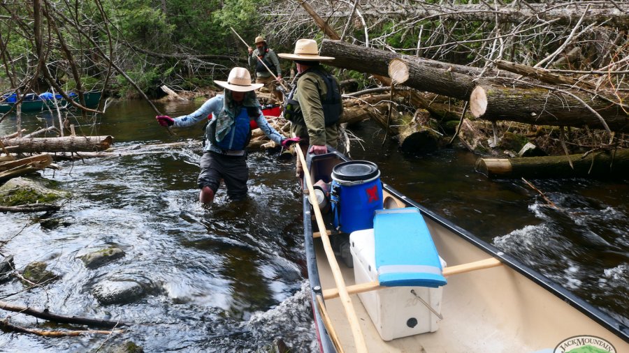 lifting canoe over logs