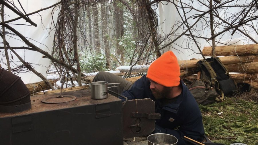 Lighting a woodstove in a shelter on a snowy day