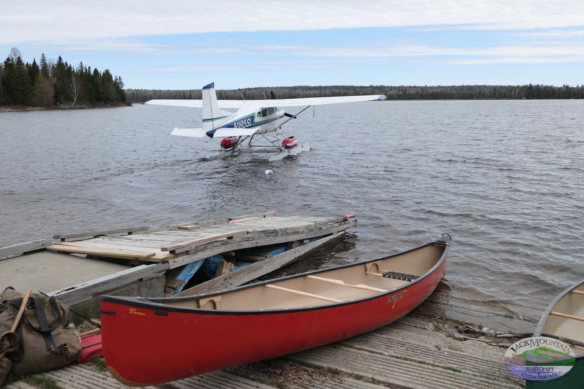 Float plane and one of our red Esquif canoes on a nearby lake