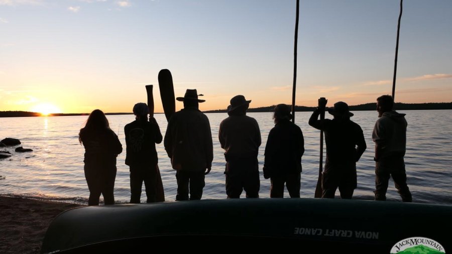 Canoe trippers on the beach watching the sunset