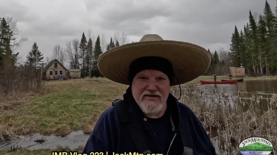 Tim walking near Grand Lac Samsquanch with canoes in the background