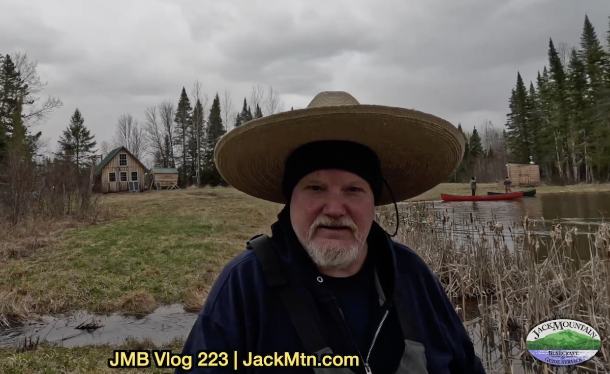 Tim walking near Grand Lac Samsquanch with canoes in the background