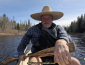 Tim seated in a canoe, cover photo for canoe poling video