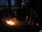 sitting by a campfire at dusk on a Maine lake